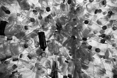 Okyanus kirliliği. Plastik yeniden kullanım. Atık yönetimi. Bulanık mavi arka planda ıslak, temiz, buruşuk şişeler var. Çevresel kirlilik.