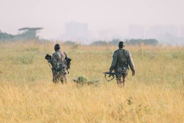 An African soldier in military uniform patrols the territory Nairobi National Park in Kenya. clipart