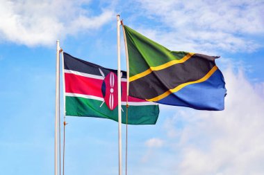 Bulutlu mavi gökyüzüne karşı Kenya ve Tanzanya bayrakları