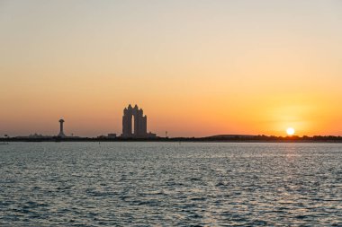 Gün batımında Abu Dabi Skyline, Birleşik Arap Emirlikleri 'nde gün batımında deniz manzarası