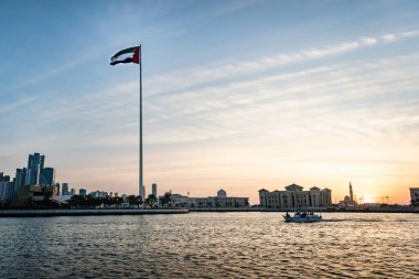 Bayrak Adası 'nın şehir manzarası, Sharjah. Gün batımında güzel gökdelenlerin arka planında bir bayrak.
