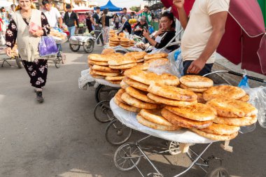 29 Ekim 2023. Semerkant, Özbekistan: Şehir marketi. Erkekler geleneksel Özbek ekmeği satıyor.