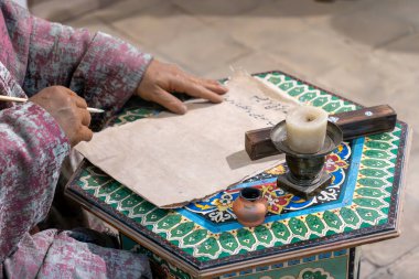 Yazar eski bir kağıda yazıyor. Orta Çağ şiirleri Semerkant Özbekistan. 30 Ekim. 2023 Semerkant Özbekistan
