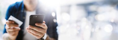 Smartphone ve kredi kartı tutan eller