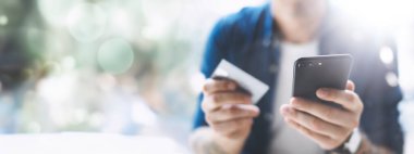 Smartphone ve kredi kartı tutan eller