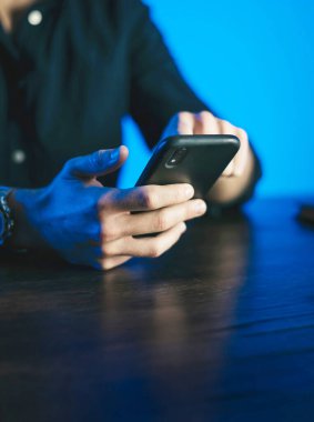 Akıllı telefon ekranını işaret eden adam, sosyal ağlarda sohbet eden, web sitesiyle buluşan, interneti arayan, mesaj gönderen, kısa mesaj çeken ya da online bankacılık kullanan. Erkek ellerine yakın çekim. Uzak çalışma