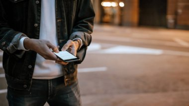 Açık havada, Night City Caddesi 'nde akıllı telefonları olan erkeklerin yakın çekimleri.