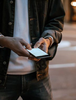 Açık havada, Night City Caddesi 'nde akıllı telefonları olan erkeklerin yakın çekimleri.