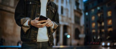 Açık havada, Night City Caddesi 'nde akıllı telefonları olan erkeklerin yakın çekimleri.