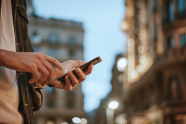 Açık havada, Night City Caddesi 'nde akıllı telefonları olan erkeklerin yakın çekimleri.