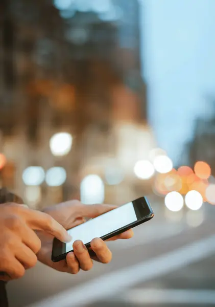 Açık havada, Night City Caddesi 'nde akıllı telefonları olan erkeklerin yakın çekimleri.
