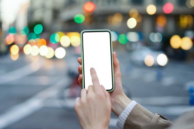 Kadın ellerinin akıllı telefonu boş ekranla tutarken yakın plan görüntüsü. Metin iletisi ya da içerik için model hazır.