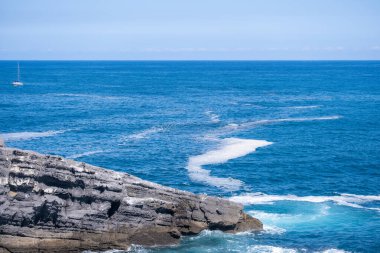 Sea coast with rocks on the side of the see. clipart