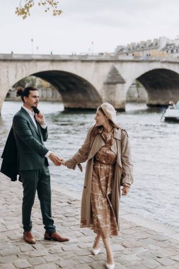 Aşık bir çift Paris sokaklarında yürüyor. Palto ve takım elbiseli bir adam. Sonbaharda bereli ve trençkotlu bir kız.