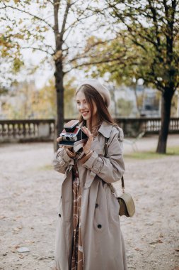 Aşık bir çift Paris sokaklarında yürüyor, ceketli ve takım elbiseli bir adam, sonbaharda bereli bir kız ve kameralı bir trençkot.