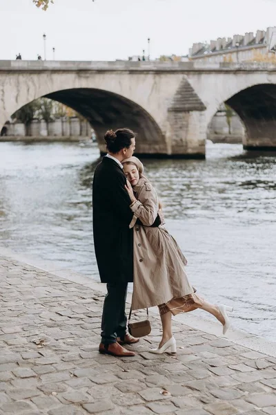 愛のカップルはパリの通り コートとスーツの男 ベレー帽と秋のトレンチコートを着た女の子に沿って歩きます — ストック写真