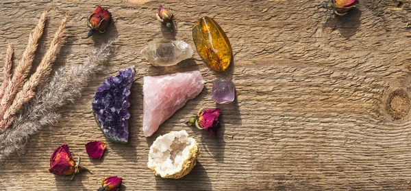 乾燥した花と木製のテーブルの上に設定されたジオードの鉱物石で 無味乾式な ピンクの石英 ルチル 石炭や石英と石英 密教の霊験 魔術の宝石 — ストック写真