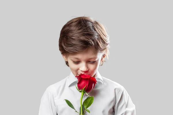 可爱优雅的白人男孩拿着一朵红玫瑰作为礼物送给他的母亲或女朋友 母亲节或情人节的概念 — 图库照片