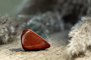 Red Jasper, Tahta Arkaplan 'da Mücevher Taşı' nı Tökezletti. Jasper süsleme ya da Gemstone olarak kullanılır.