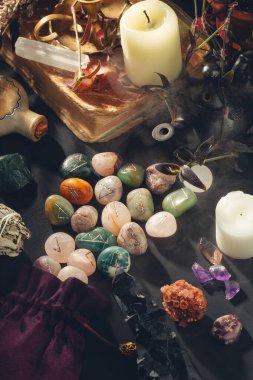 Witchcraft Equipment on Black Background. Esoteric Occult Altar with Runes Stones, Crystals, Candles, Old Book Shrouded in Mystical Mist