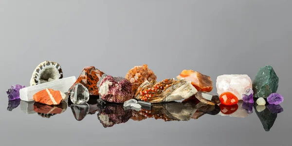 Szeroki Sztandar Grupą Kolorowych Kamieni Minerałów Ułożonych Rzędzie Powierzchni Refleksyjnej — Zdjęcie stockowe
