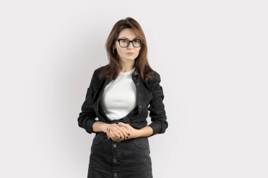 Kendine güvenen Stylish Woman Ayakta Stüdyo Portresi. 30 'lu yaşlarda şık bir iş kadını. Günlük kıyafetler ve gözlük takıyor. Kameraya bakıyor.