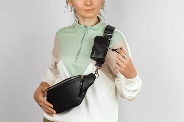 Genuine Leather Waist Bag with Removable Coin Purse Accessory for Storing Keys, Cigarette or Earphones Attached to the Strap on the Female Model over Gray Background, Studio Shot