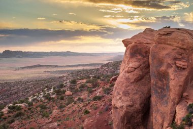 Utah, Arches Ulusal Parkı 'ndaki Devils Garden Trail' den çarpıcı bir günbatımı manzarası. Engebeli kızıl kaya oluşumları ve geniş çöl manzaraları batan güneşin sıcacık parıltısıyla aydınlanır..