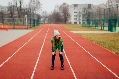Koşucu kış sporları sahasında antrenmandan sonra dinleniyor. Kadın dışarıda çalışıyor. Sportif yaşam tarzı. Tüm vücut portresi