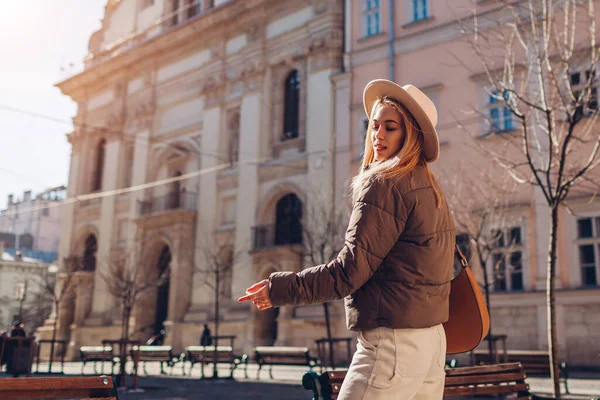 유행하는 여자가 모자와 재킷을 도시의 거리를 있습니다 갈색의 액세서리를 놓는다 — 스톡 사진