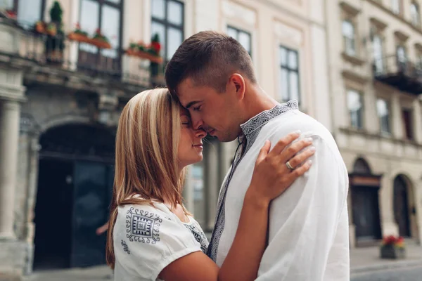 stock image Couple in love walking in old Lviv city wearing traditional ukrainian shirts. People hug relaxing outdoors enjoying time together