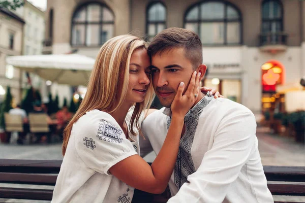 伝統的なウクライナのシャツを着た古いリヴィウ市でリラックスしたカップルを愛しています 新婚旅行は広場で一緒に時間を過ごす — ストック写真