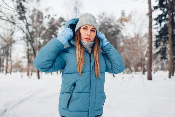 年轻女子穿着蓝色外套在雪地的冬季公园里行走的画像 冷天穿保暖衣服 — 图库照片
