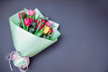 Kadınlar Günü 'nde. Bahar çiçekleri. Kadınlar günü geçmişi. Kurdeleli sarı ve pembe lalelerden oluşan bir buket. Anneler Günü için hediye. Boşluk. Üst görünüm