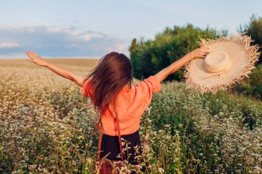 Gün batımında Buckweat sahasına atlayan ve dışarıda eğlenen genç bir kadın. Rahatlatıcı manzaranın tadını çıkarmak, özgür ve mutlu hissetmek.