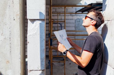 İnşaat halindeki evi kontrol eden mimar bir adamın portresi. Proje gaz bloğundan inşa ediliyor