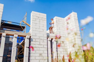 Düşük açılı çekimde, genç bir kadın inşaat halindeki evini kontrol ediyor. Birinci katta, pencere boşluğunda duruyor. Müstakbel sahibi gaz bloğundan yapılmış rahat bir ev hayal ediyor.