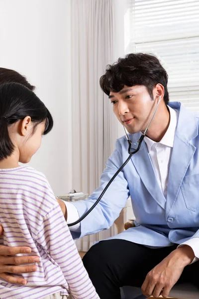 Asian korean mother with her daughter visiting doctor in clinic