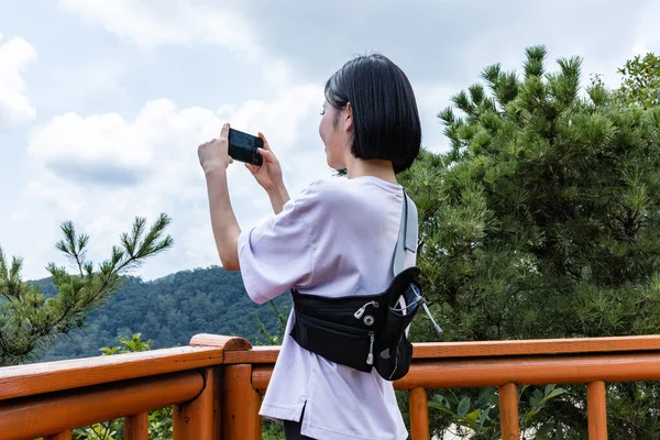 stock image korean young woman hiker taking photo on smartphone