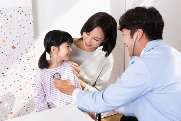 Asian korean mother with her daughter visiting doctor in clinic