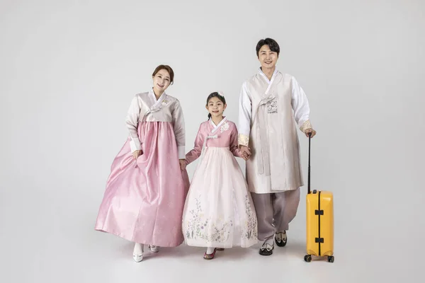 汉博克的韩国家庭拿着手提箱 背景是白色的工作室 — 图库照片