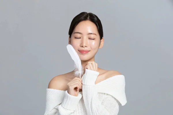 beautiful young Korean Asian woman portrait studio photo in winter skin beauty and cosmetics concept, hand motion