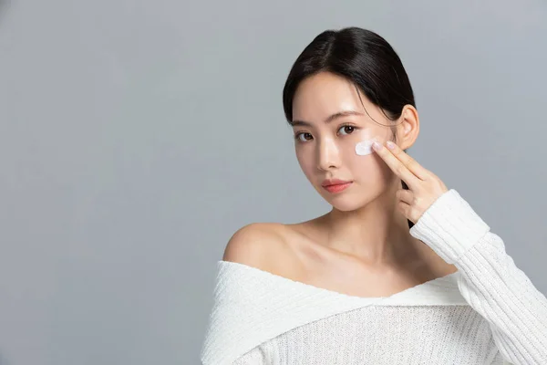 beautiful young Korean Asian woman portrait studio photo in winter skin beauty and cosmetics concept, use nourishing cream