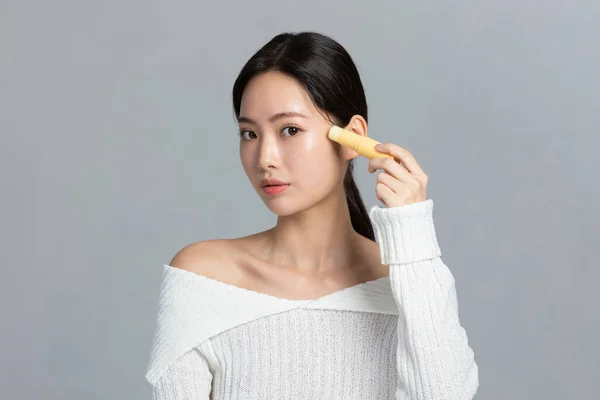 beautiful young Korean Asian woman portrait studio photo in winter skin beauty and cosmetics concept, apply a multi bam