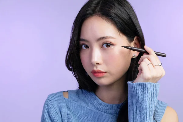 美丽的年轻的韩国亚洲女子肖像工作室照片在冬季皮肤美感和化妆品的概念 持有眼线笔 — 图库照片