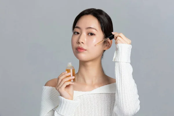 beautiful young Korean Asian woman portrait studio photo in winter skin beauty and cosmetics concept, apply an ample