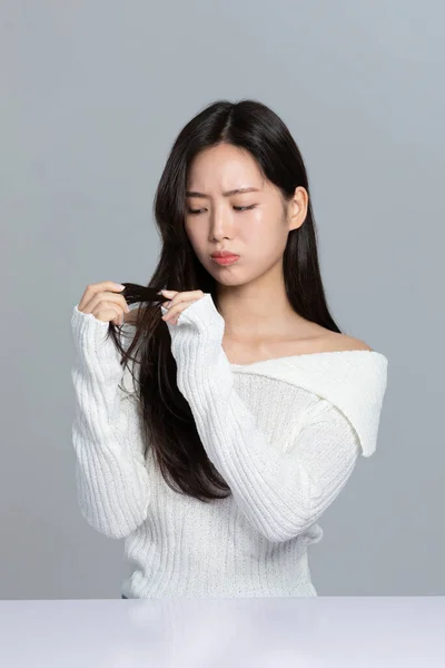 美丽的年轻的韩国亚洲女子肖像工作室照片冬季皮肤美感与化妆品的概念 担心干枯的头发 — 图库照片