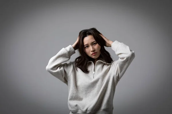 stock image stressed, depressed Korean business woman in pink suit, worrying