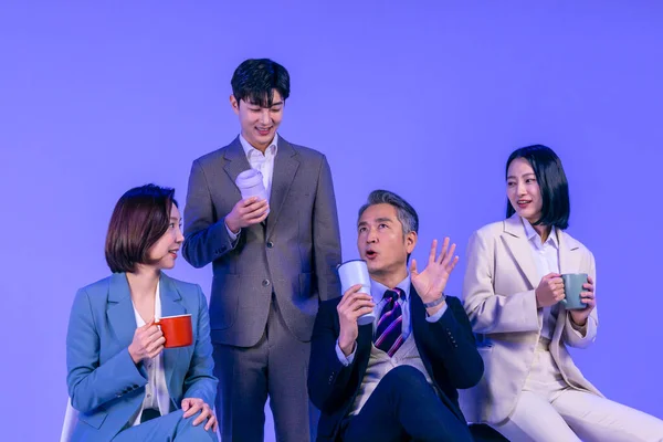 アジア系韓国人シニア 中高年 若い男性と女性の同僚モデルでビジネス服装 ネオンパープルのスタジオの背景 コーヒーとチャットを持っています — ストック写真