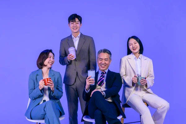 アジア系韓国人シニア 中高年 若い男性と女性の同僚モデルでビジネス服装 ネオンパープルのスタジオの背景 コーヒーとチャットを持っています — ストック写真